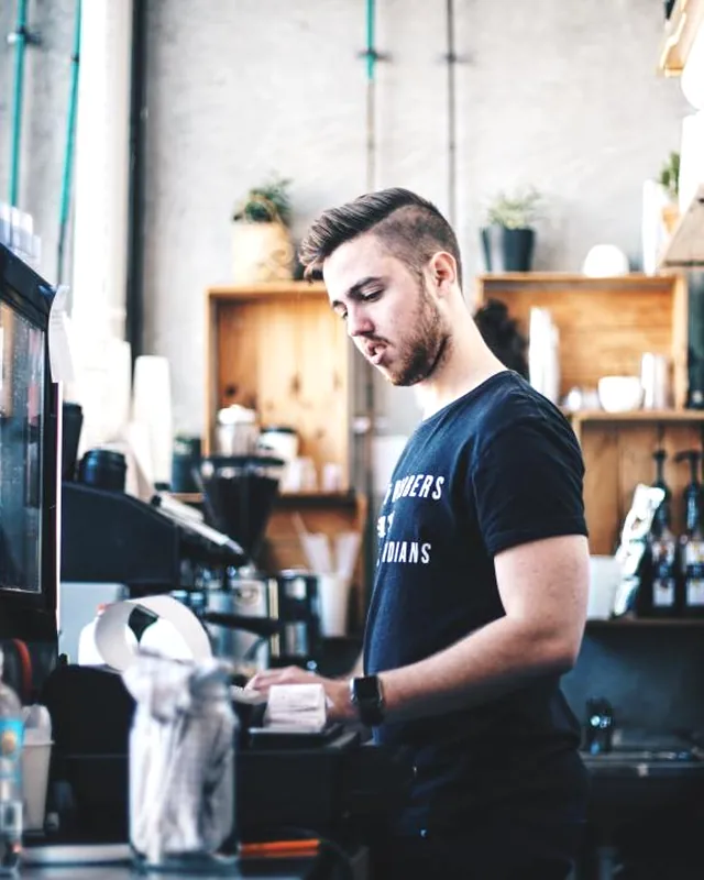 Comptoir de café indépendant avec ardoise et gâteaux du jour.